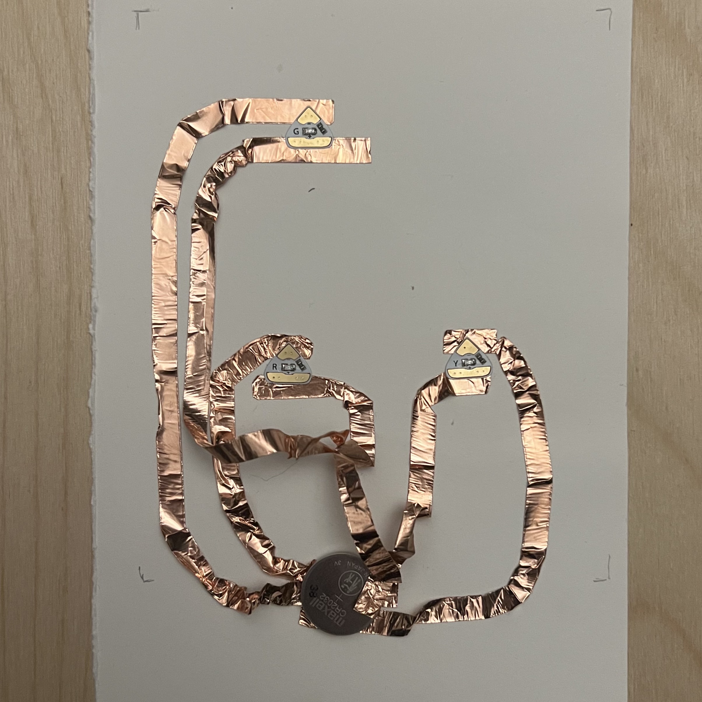 Circuit made using copper tape, LED lights, battery and a paper base