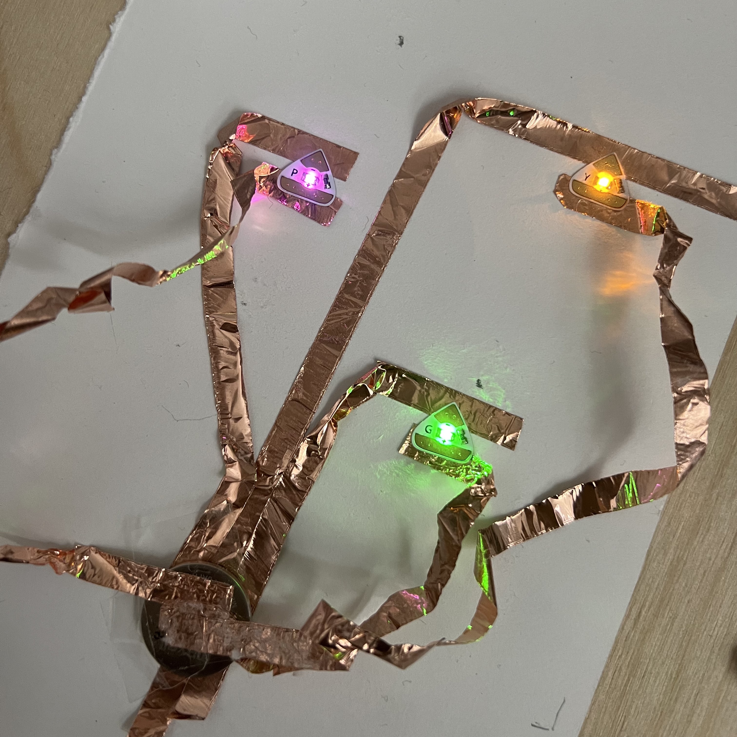 Circuit made using copper tape, LED ligths, battery and a paper base